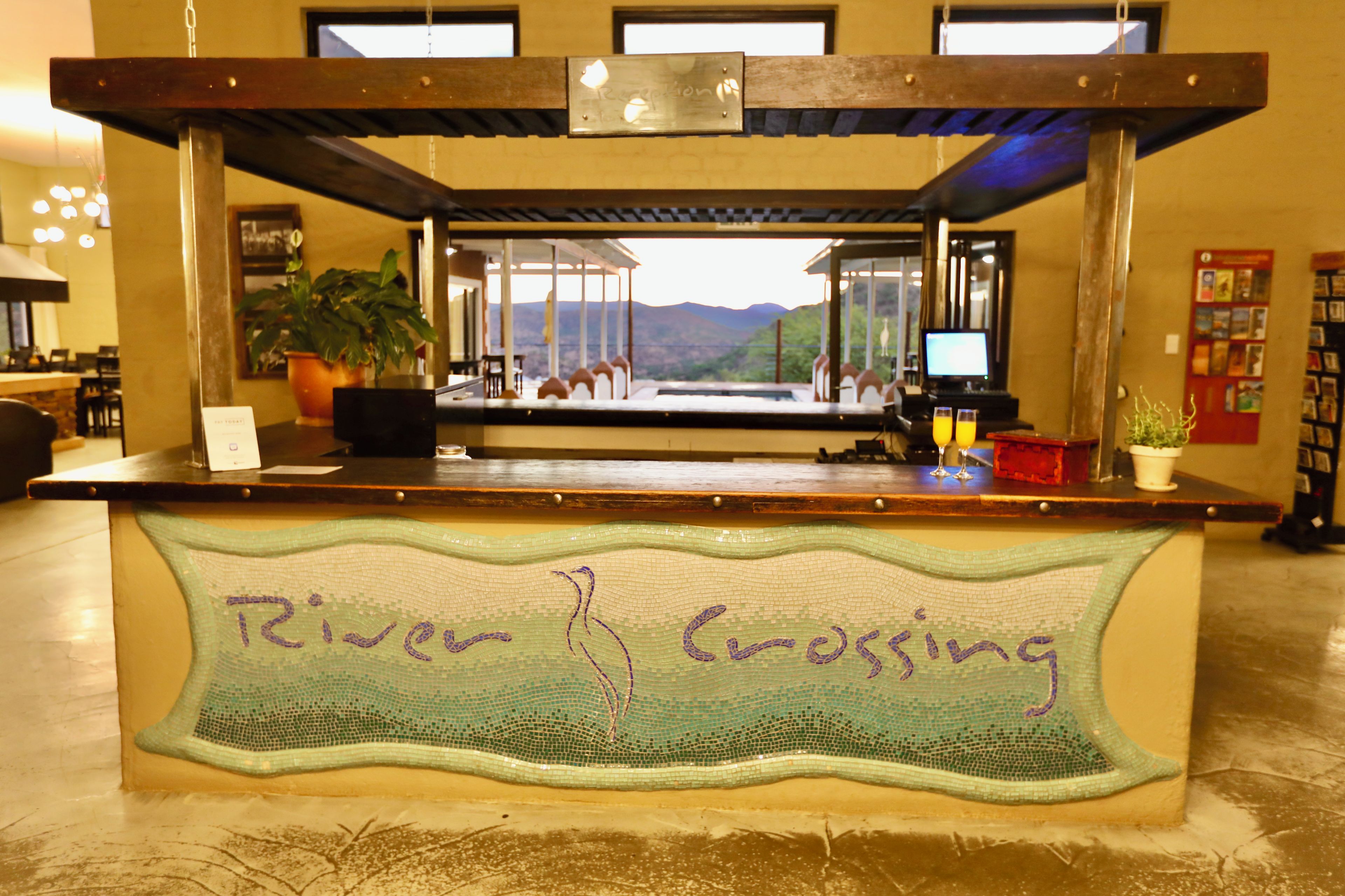 A reception desk with a view of mountains through large windows.
