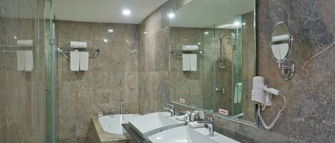 A modern bathroom with a glass shower enclosure, a double sink vanity, and a large mirror.