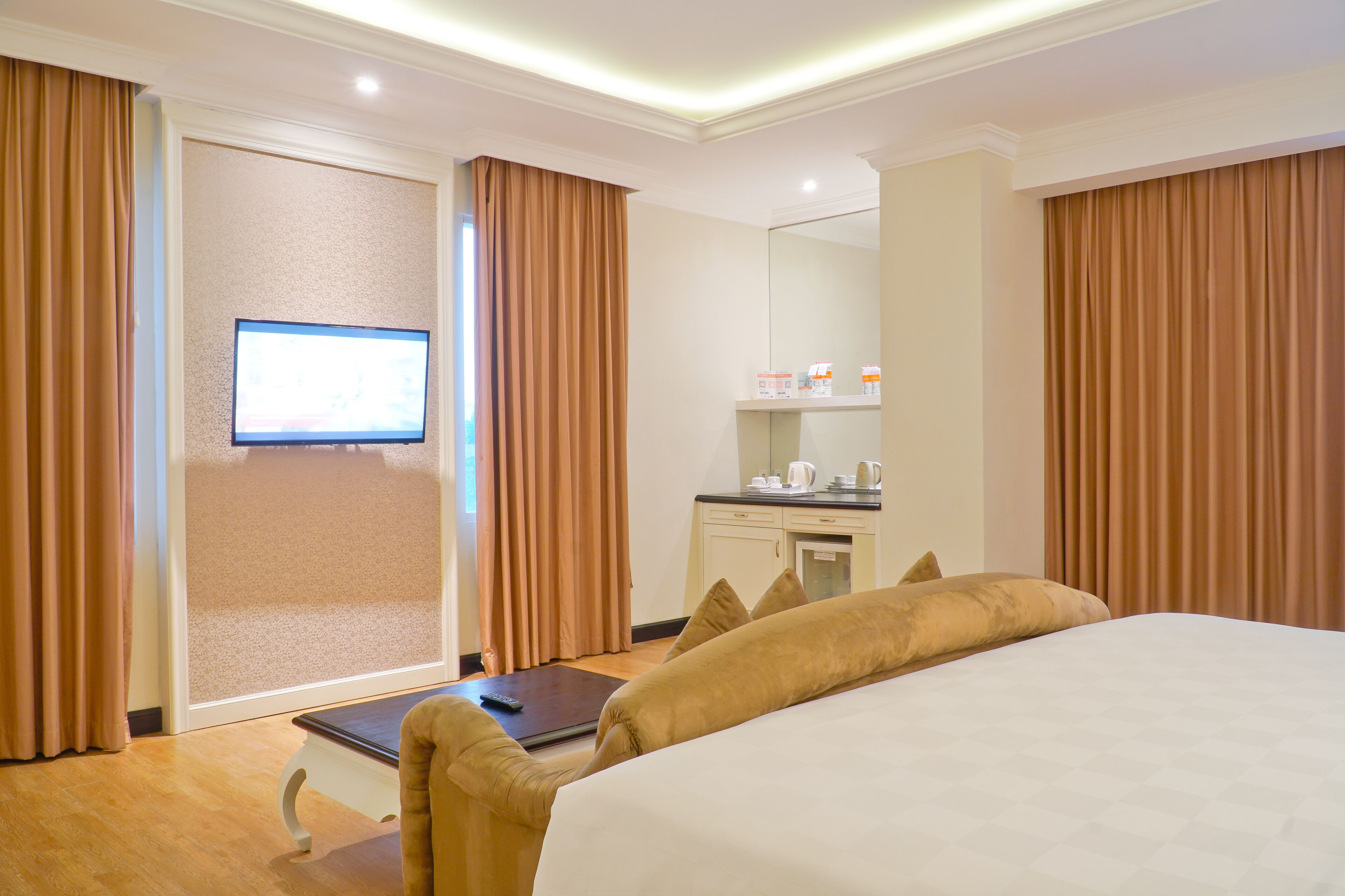 A hotel room with a large bed, a desk, a television, and a sliding door.