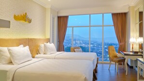 Une chambre d’hôtel avec deux lits, un bureau, une chaise et une grande fenêtre donnant sur la ville.