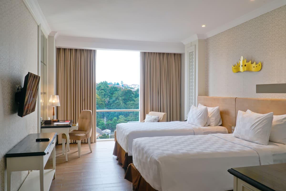 Une chambre d’hôtel avec deux lits, un bureau, une chaise et une télévision.