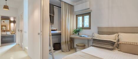 Quarto com cama, mesa de cabeceira, cortinas e janela.