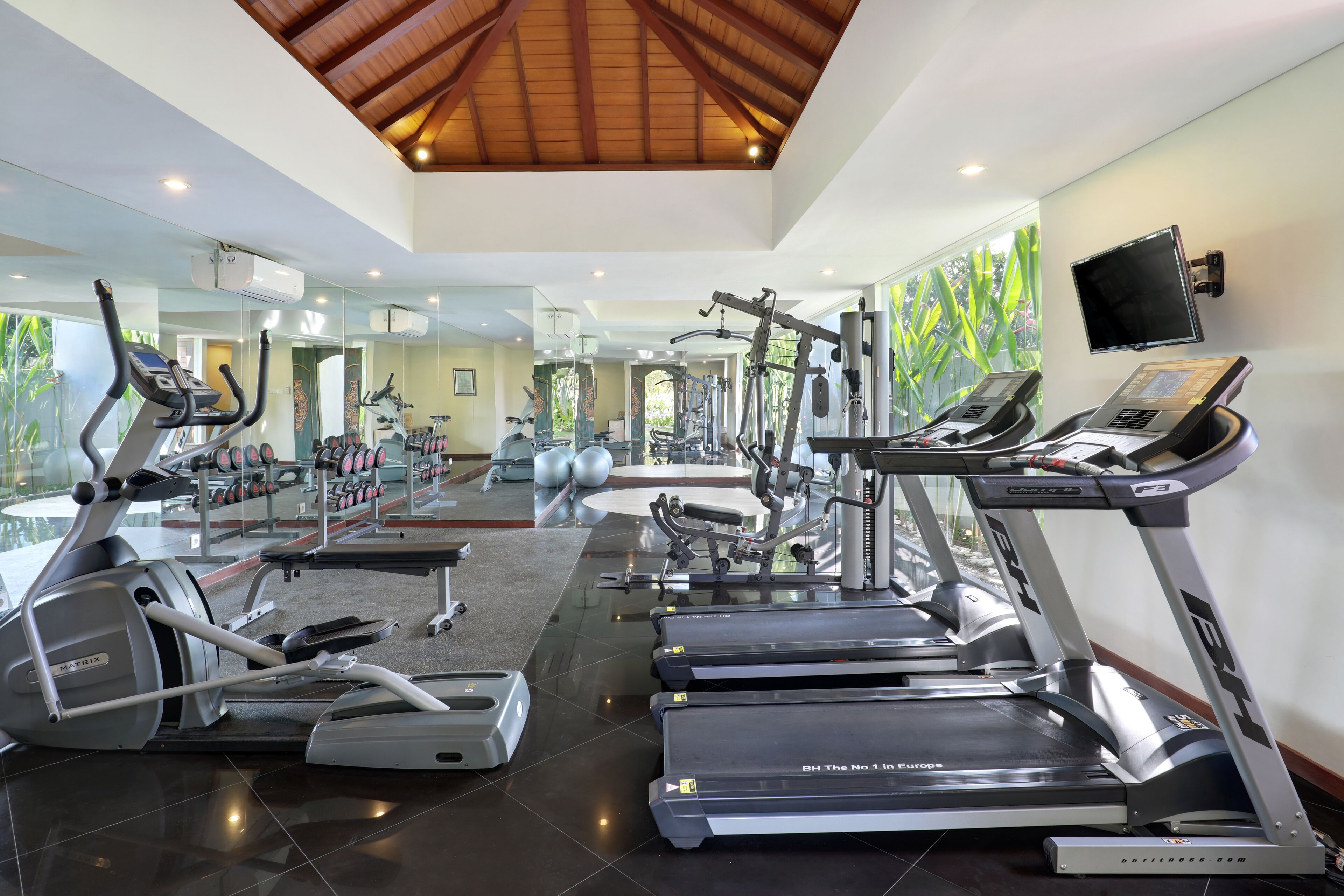 Ein modernes Fitnessstudio mit Laufbändern, Crosstrainern und Gewichtsgeräten.