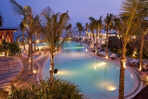 A pool area with palm trees, lounge chairs, and a circular water feature. - The Royal Purnama Luxury Villas - Adults Only (Sukawati)