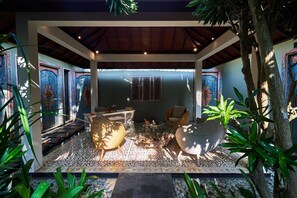 A covered outdoor area with a patterned floor, seating arrangements, and decorative doors. - The Royal Purnama Luxury Villas - Adults Only (Sukawati)