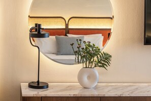 A modern bedroom with a bed, a bedside lamp, and a vase with flowers. - Kerkyra Blue Hotel & Spa by Louis Hotels (Corfu)