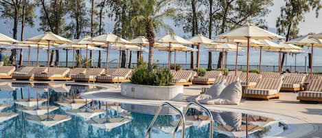 Una piscina al aire libre de temporada, sombrillas, tumbonas