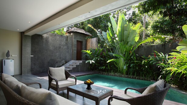 A modern outdoor pool area with wicker furniture and a thatched-roof structure. - The Canggu Boutique Villas (Tibubeneng)