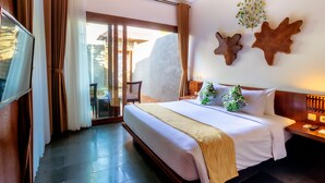 A hotel room with a large bed, a TV, a wooden headboard, a nightstand, and a view of the outdoors. - The Canggu Boutique Villas (Tibubeneng)