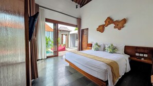 A spacious bedroom with a large bed, a wooden headboard, and a view of a pool and outdoor area. - The Canggu Boutique Villas (Tibubeneng)