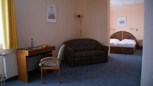 Une chambre d’hôtel avec un lit, un bureau, une chaise et un canapé.