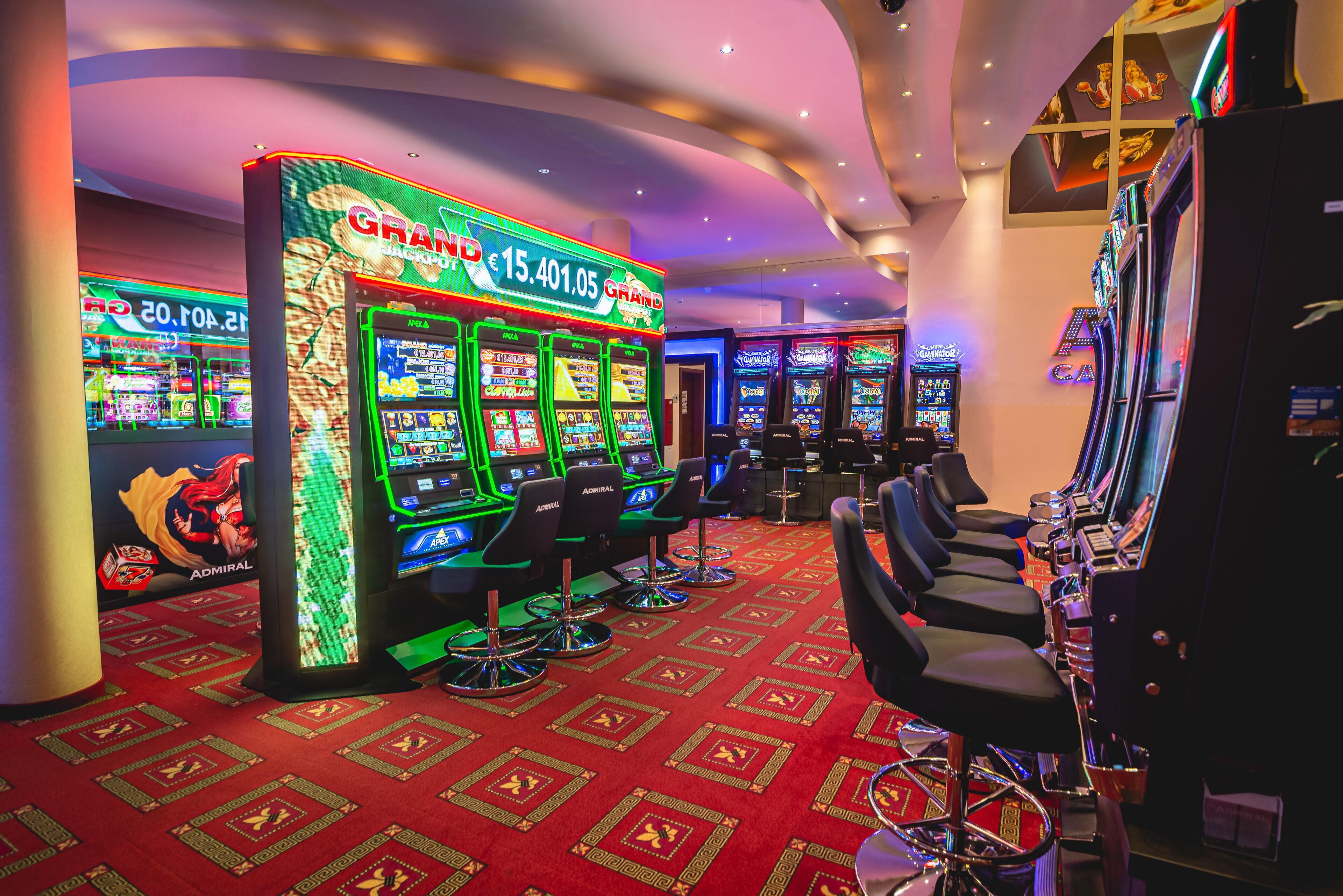 A casino with multiple slot machines and bar seating.