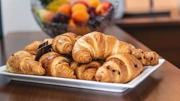 A plate of croissants on a white rectangular plate.