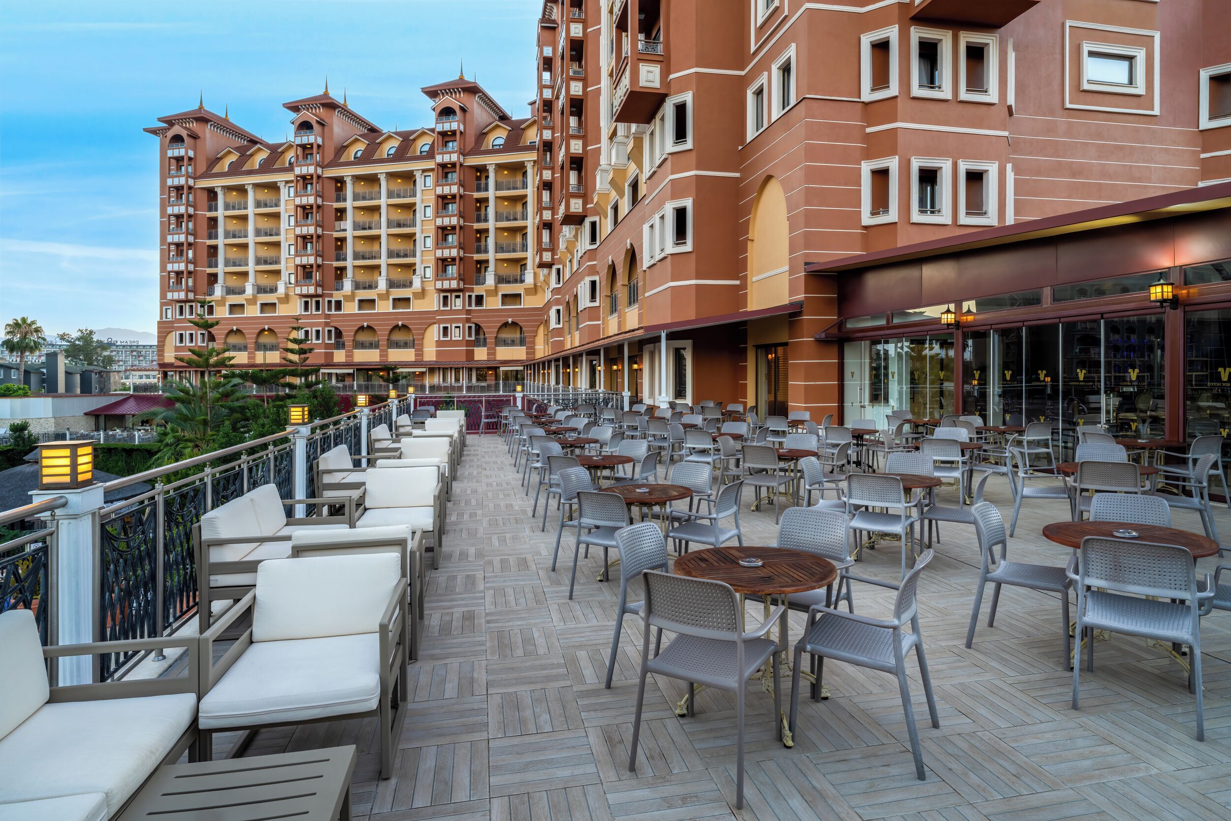 Een hotel met buiten zitplaatsen, meerdere verdiepingen en balkons.