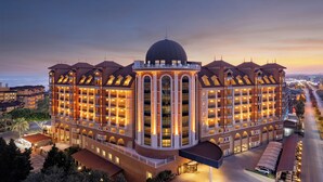 Een groot, meerlaags hotel met een centrale koepel en meerdere balkons, gelegen in een goed verlicht stadsgebied.