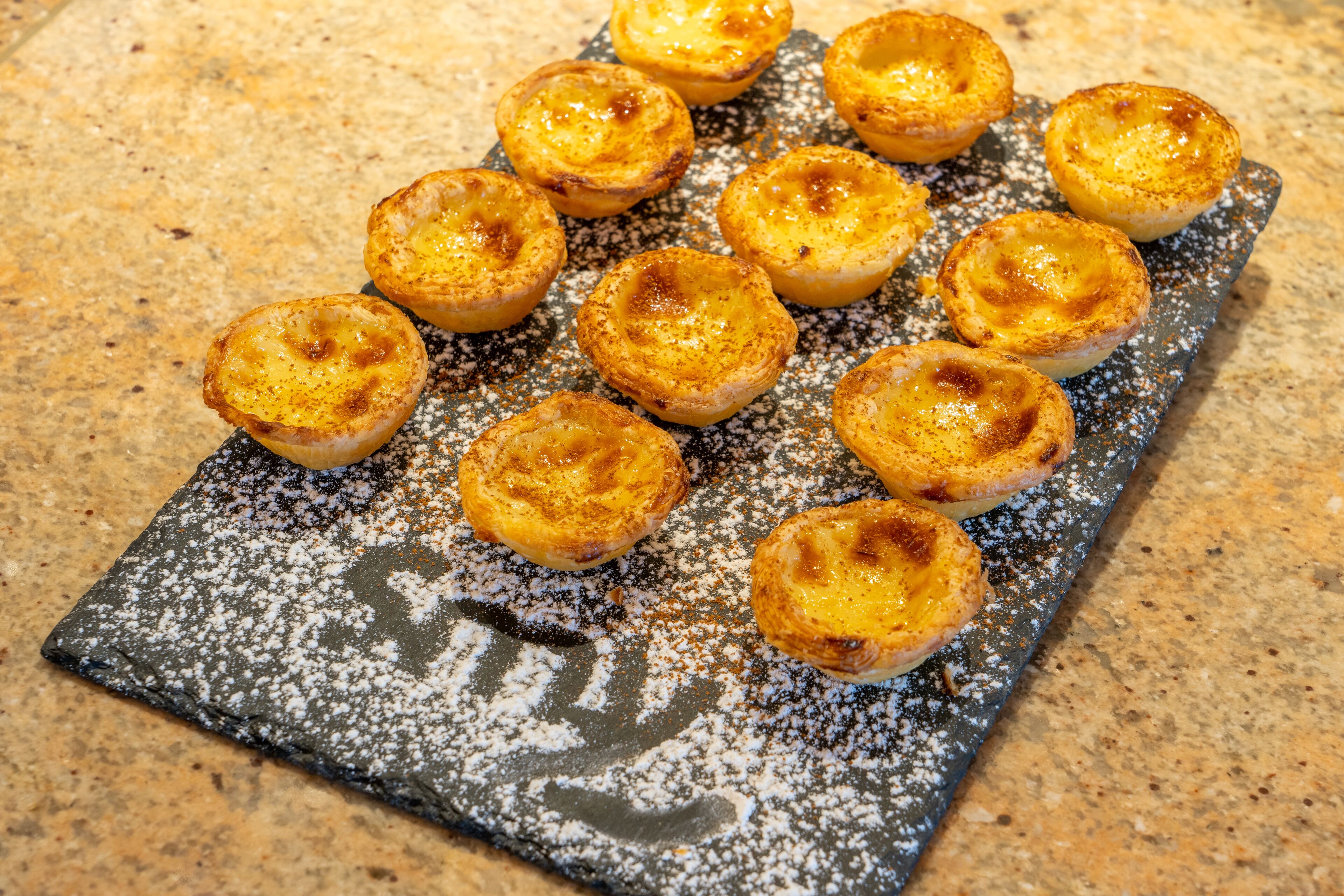 A tray of freshly baked pastries on a textured surface.