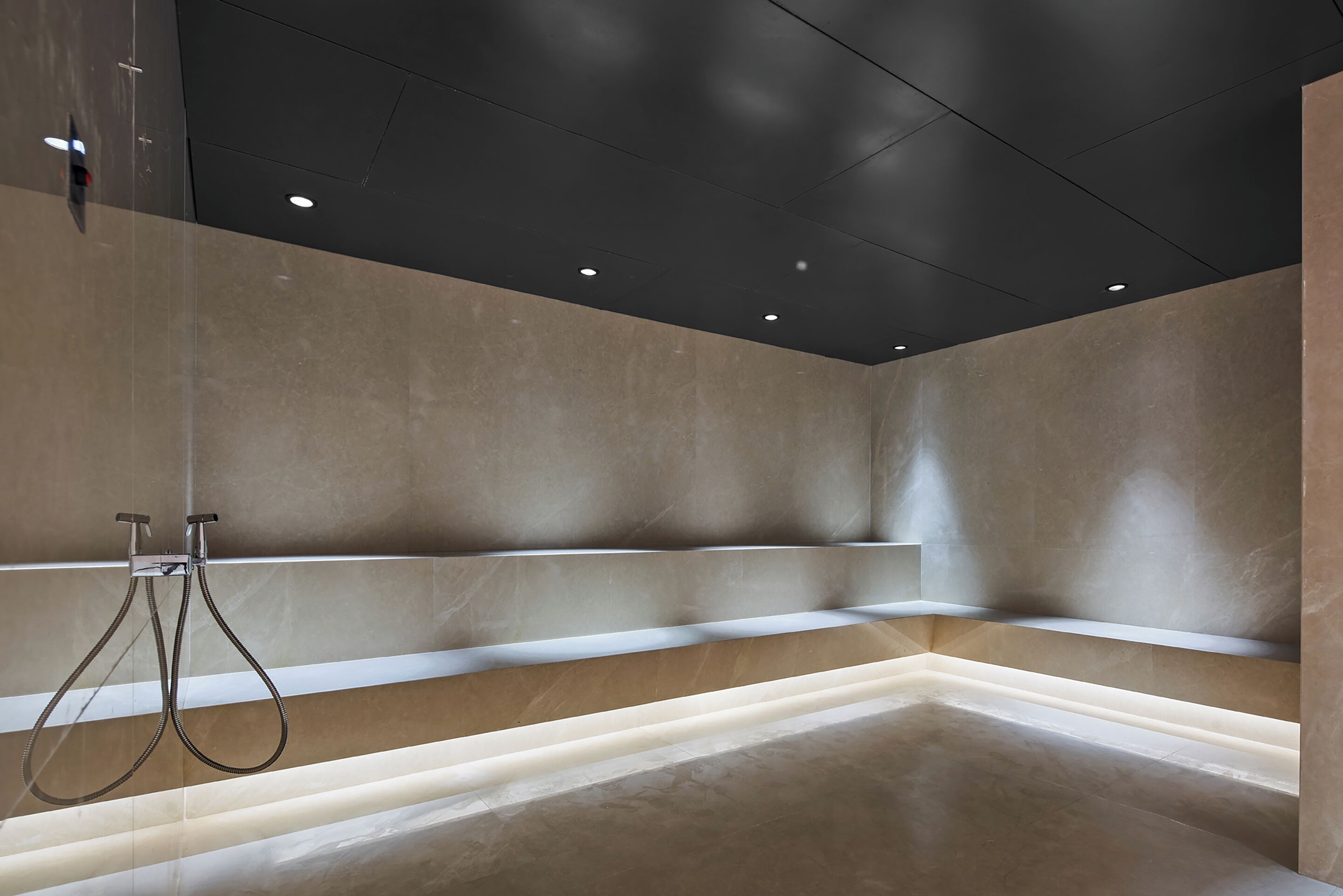 A modern bathroom with a large bathtub, a shower area, and a glass partition.