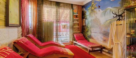 A spa room with massage beds, a large mural, and an air conditioning unit.