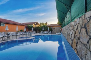 室外游泳池，池畔遮阳伞，日光浴躺椅