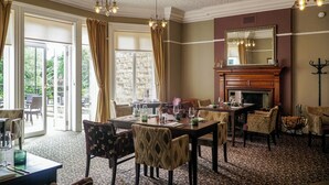 Un coin repas agrémenté d’une cheminée, de chaises à motifs et d’une table mise pour le repas.