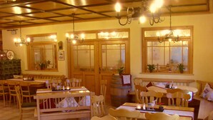 A cozy restaurant with wooden furniture, multiple tables, and a warm ambiance. - Hotel & Restaurant Engel (Herbertingen)