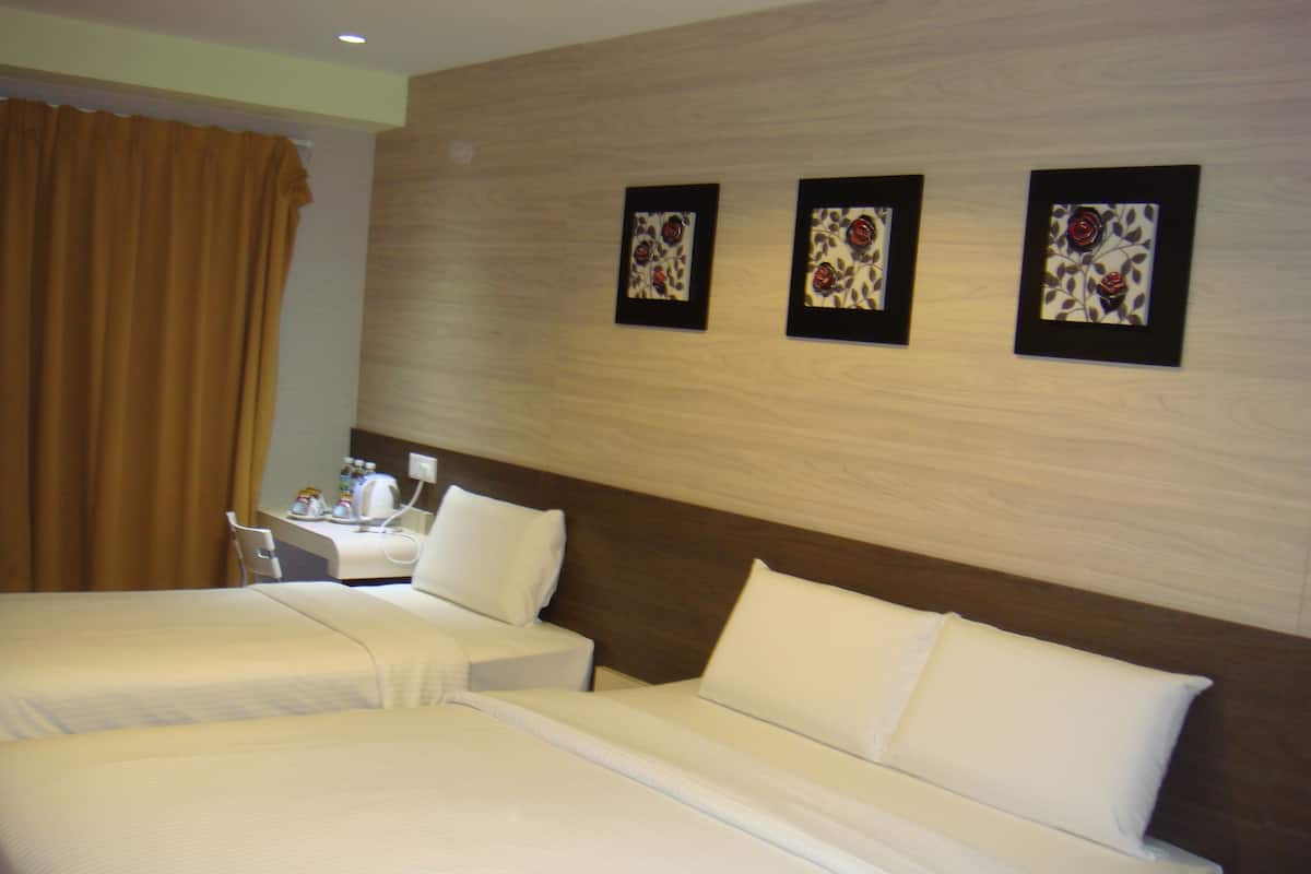 A hotel room with two beds, a bedside table, and a wall-mounted artwork.