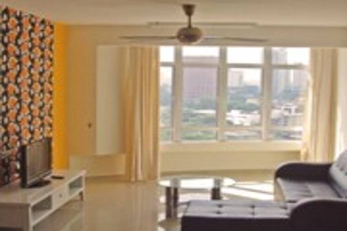 A modern living room with a sofa, a coffee table, and a television on a stand.