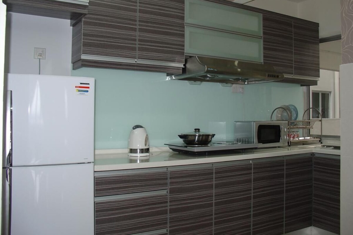 A modern kitchen with a white refrigerator, a stove, a microwave, and dark wooden cabinets.