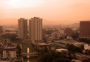A high-rise building complex with multiple floors, surrounded by smaller buildings and a body of water. - Duta Hotel & Residence (Kuala Lumpur)