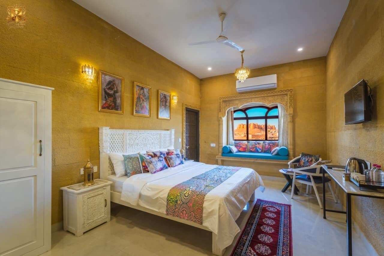 Habitación de hotel con cama, mesita de noche, silla y ventana con vistas.