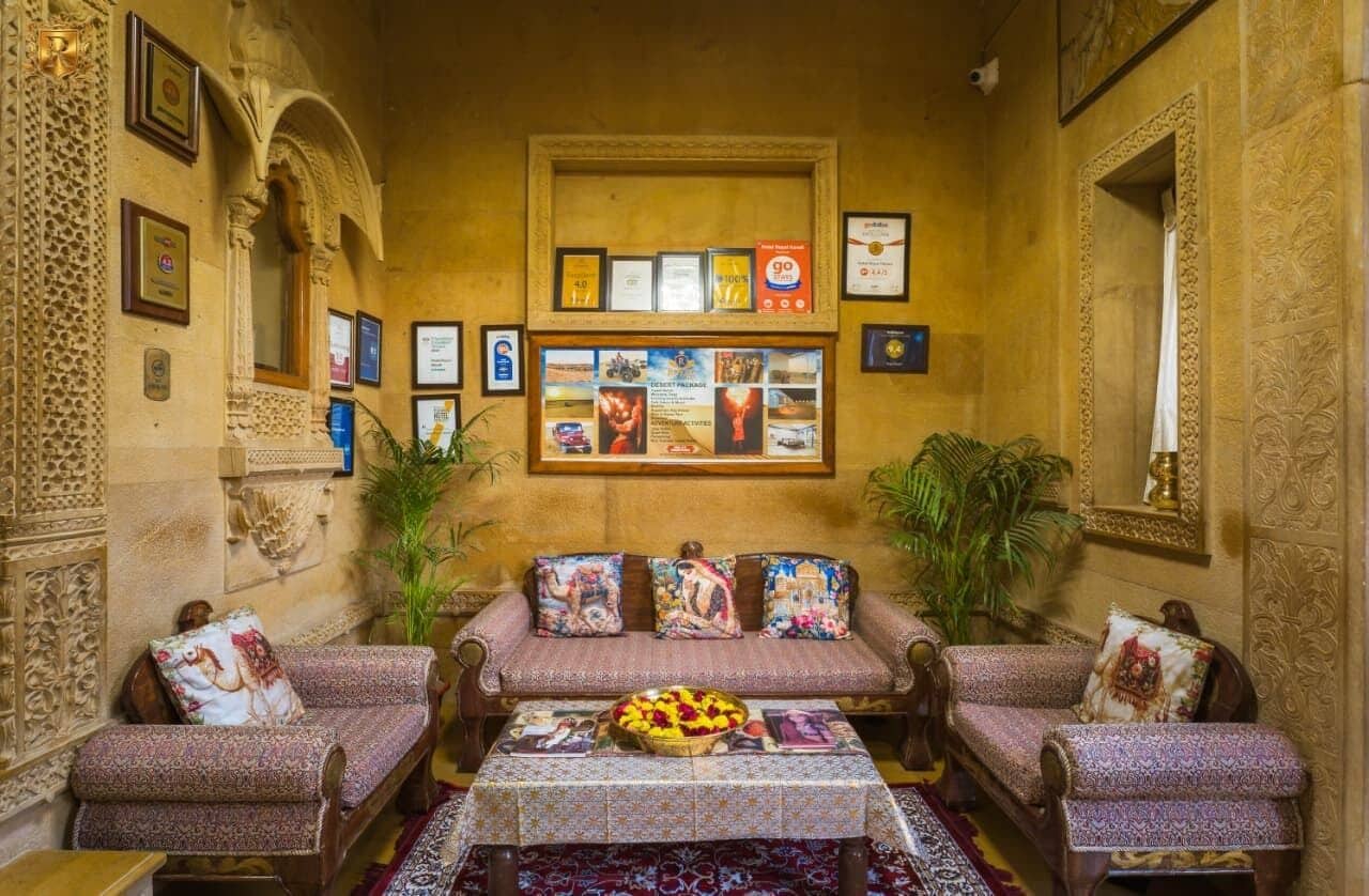 Een klassiek interieur met een zithoek, ingelijste certificaten en een centrale tafel met bloemen.