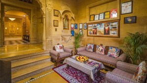 Un intérieur traditionnel agrémenté d’arches décoratives, d’un ensemble de meubles de salon et de tableaux encadrés aux murs.
