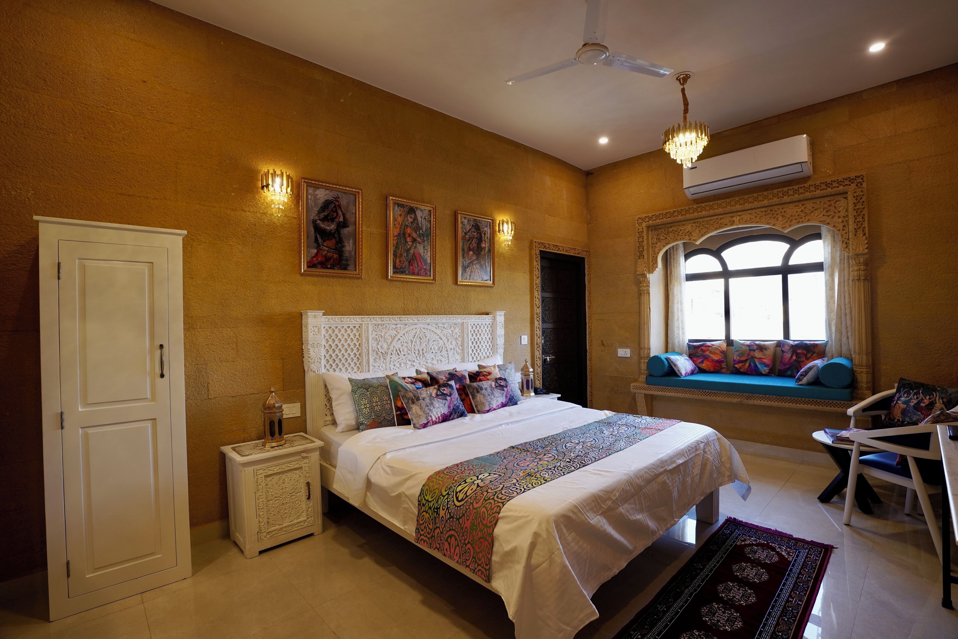 A bedroom with a bed, bedside tables, a window with a view, a ceiling fan, and wall-mounted artwork.