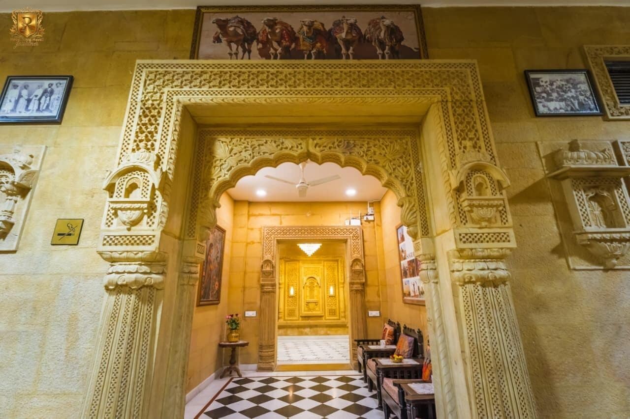 Uma entrada ornamentada com esculturas detalhadas, piso xadrez e quadros nas paredes.