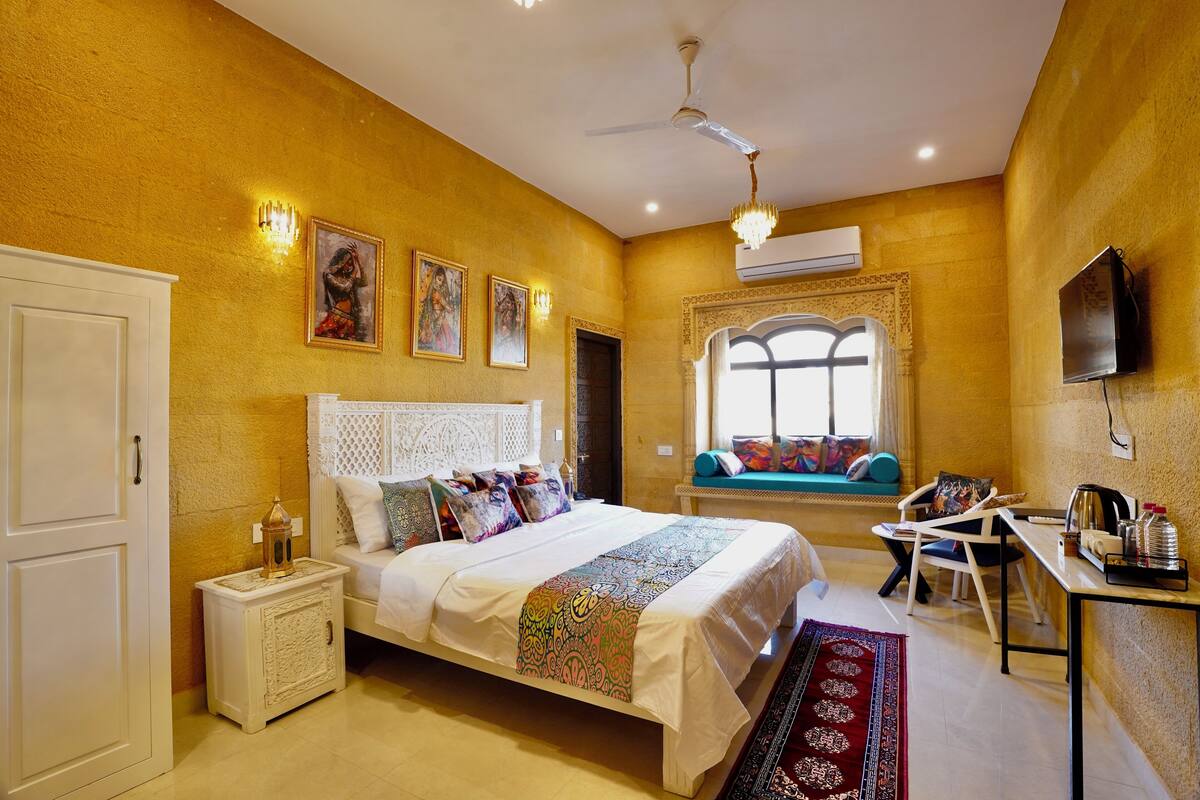 Une chambre à coucher comprenant un lit, une table de chevet, une chaise, un bureau et une fenêtre donnant sur un paysage agréable.