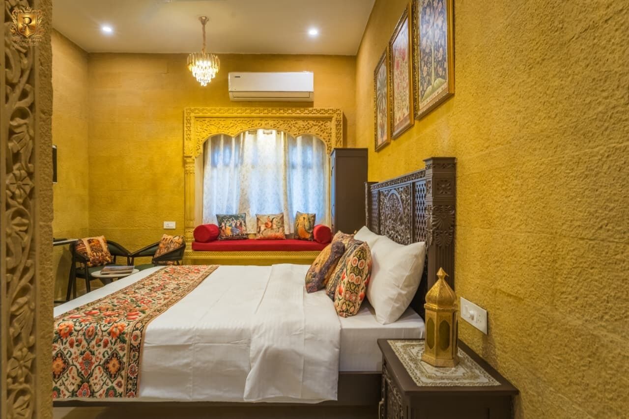 Une chambre d’hôtel avec un grand lit, un canapé, un lustre et un mur décoratif.