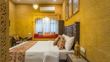 Une chambre d’hôtel avec un grand lit, un canapé, un lustre et un mur décoratif.