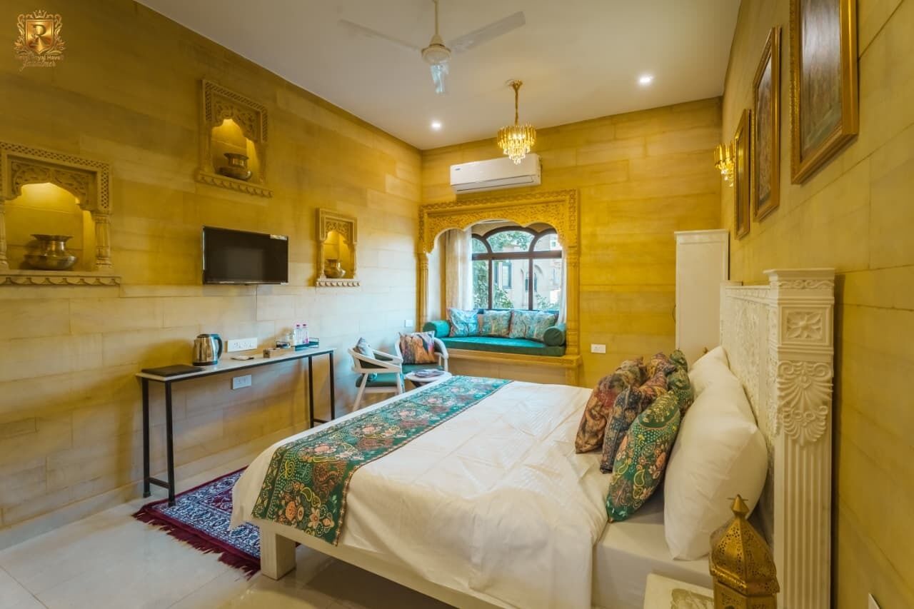 Une chambre d’hôtel équipée d’un lit, d’un bureau, d’une chaise, d’une télévision et d’une fenêtre donnant sur un paysage agréable.