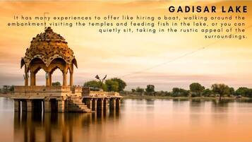 A serene lakeside view with a traditional pavilion structure, offering activities like boating and temple visits.
