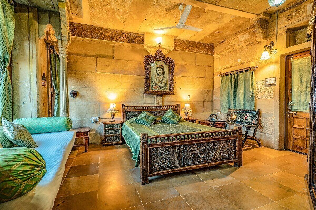 A traditional room with a large bed, two bedside tables, a ceiling fan, and a wall-mounted painting.