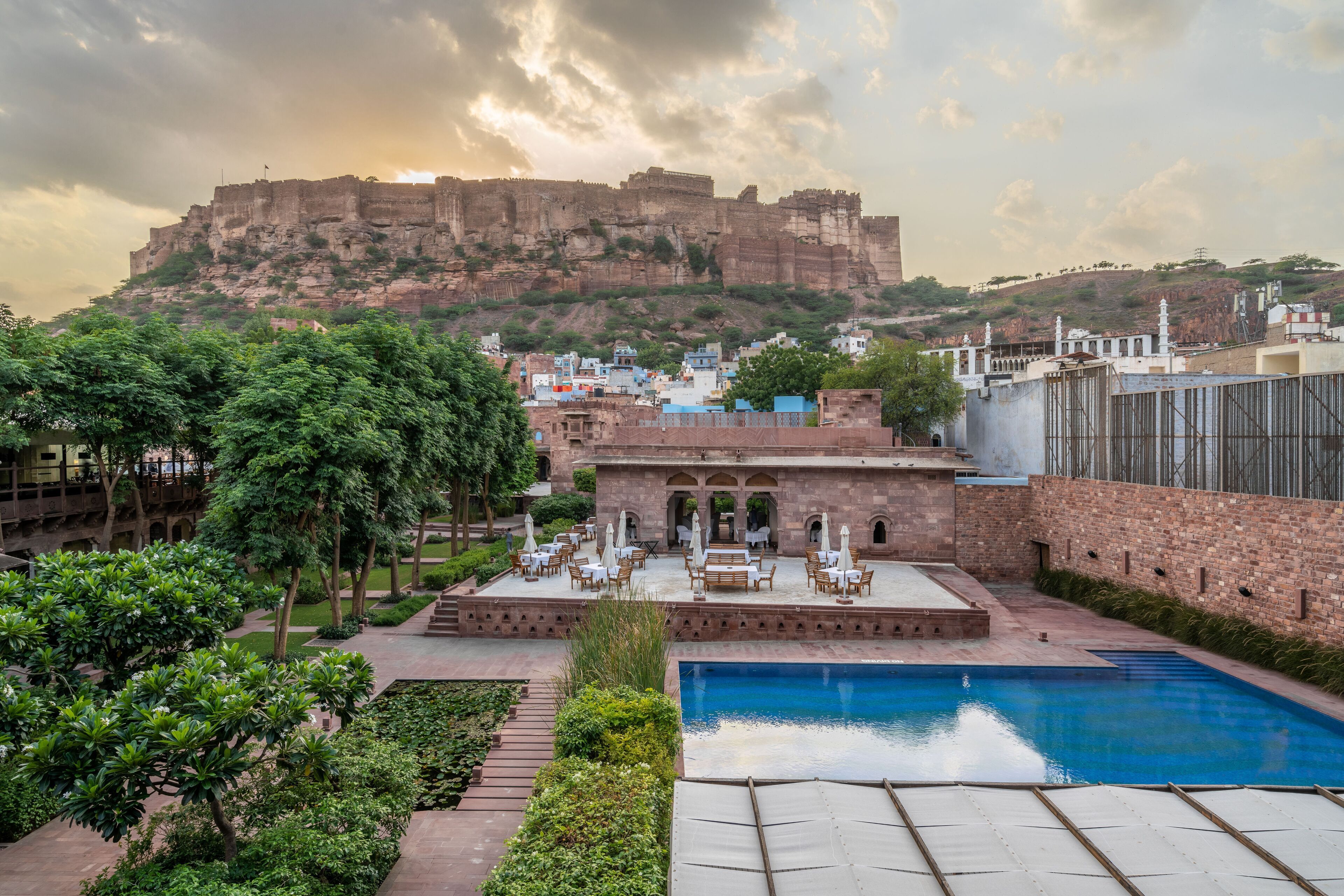 A rooftop pool area with a view of a historic fort in the background.