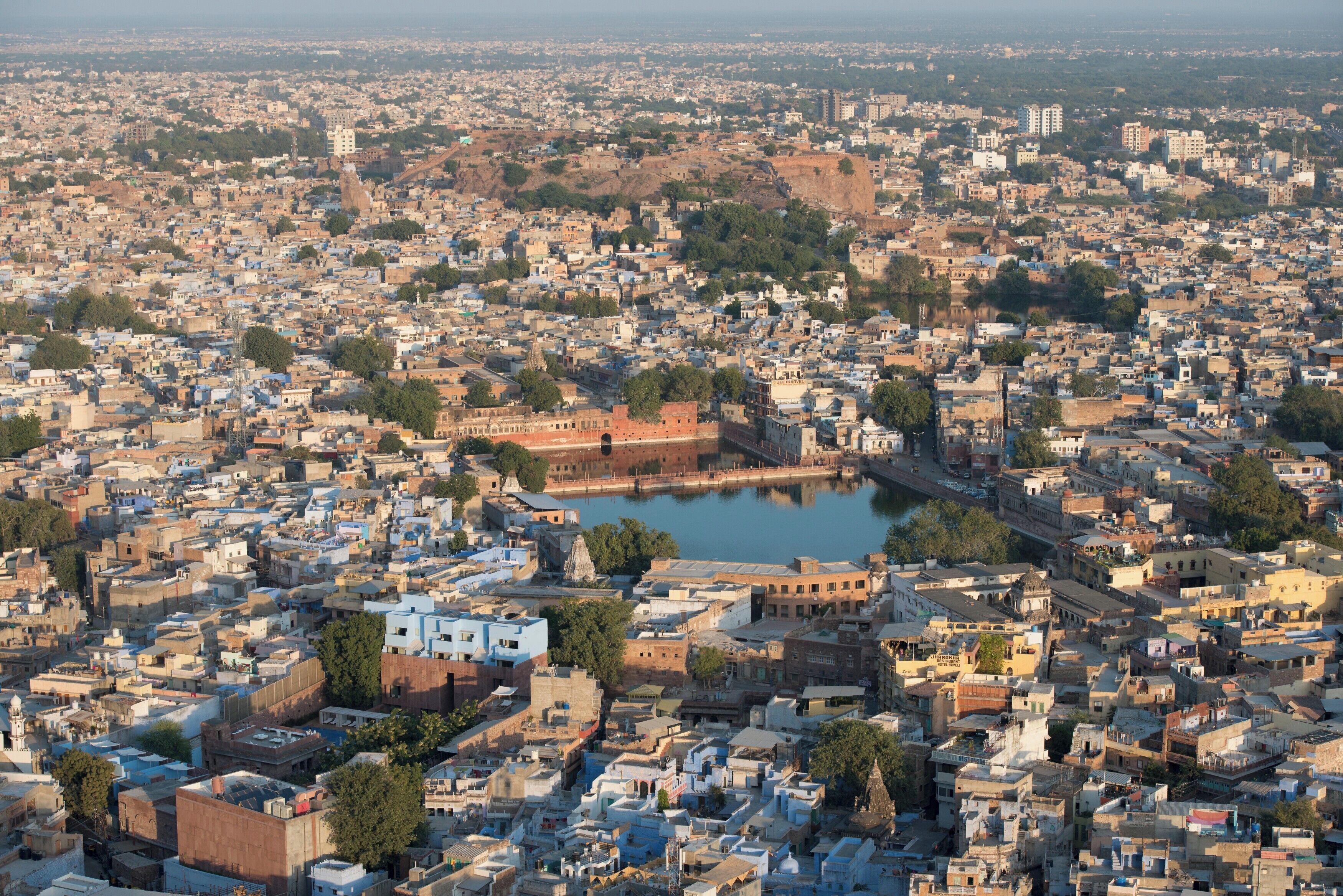Una zona urbana densamente poblada con una imponente fortaleza histórica y una extensa masa de agua.