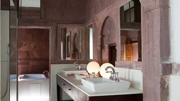 Un bagno con due lavandini, una vasca e uno specchio.