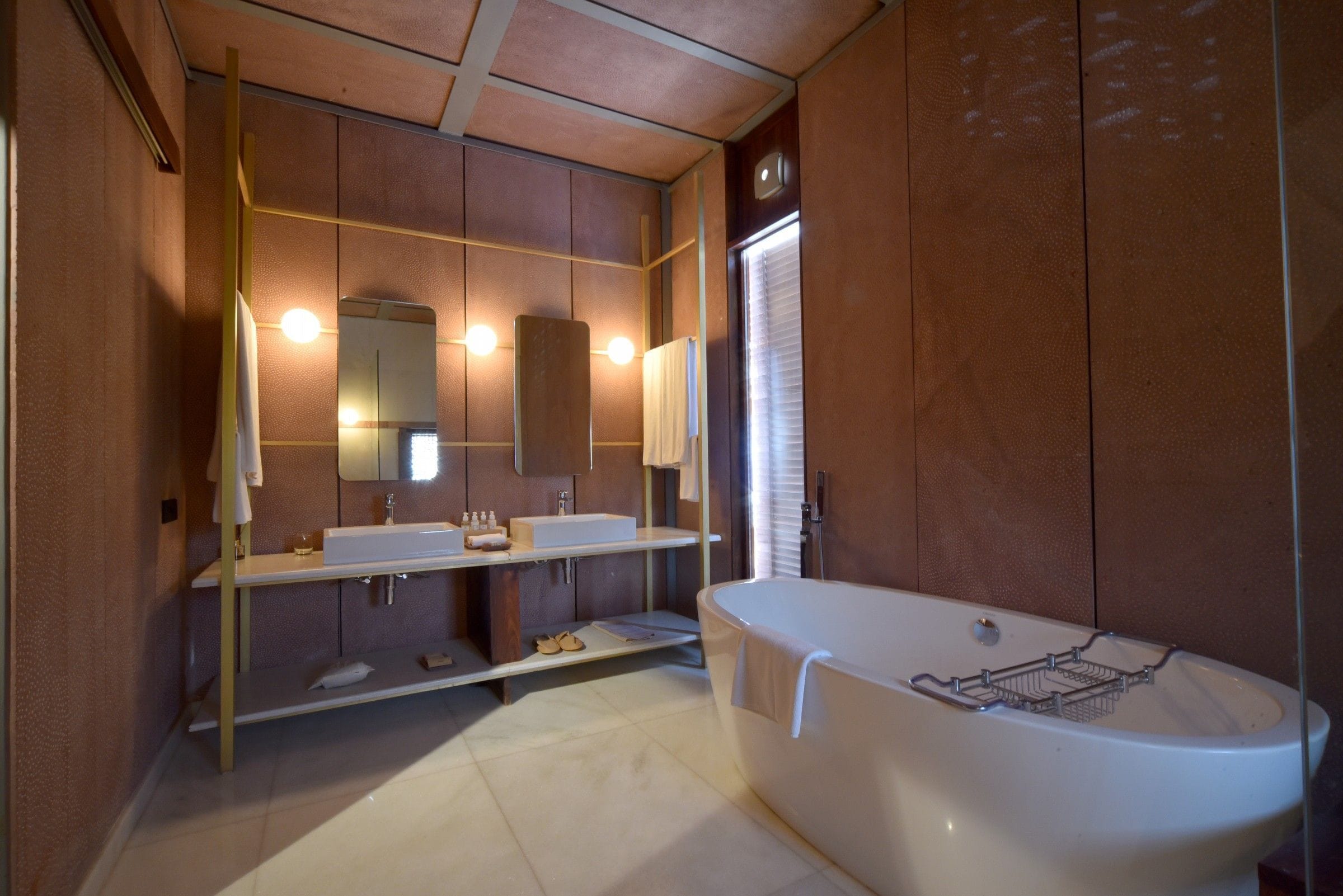 A modern bathroom with a freestanding bathtub, dual sinks, and a vanity with a mirror.