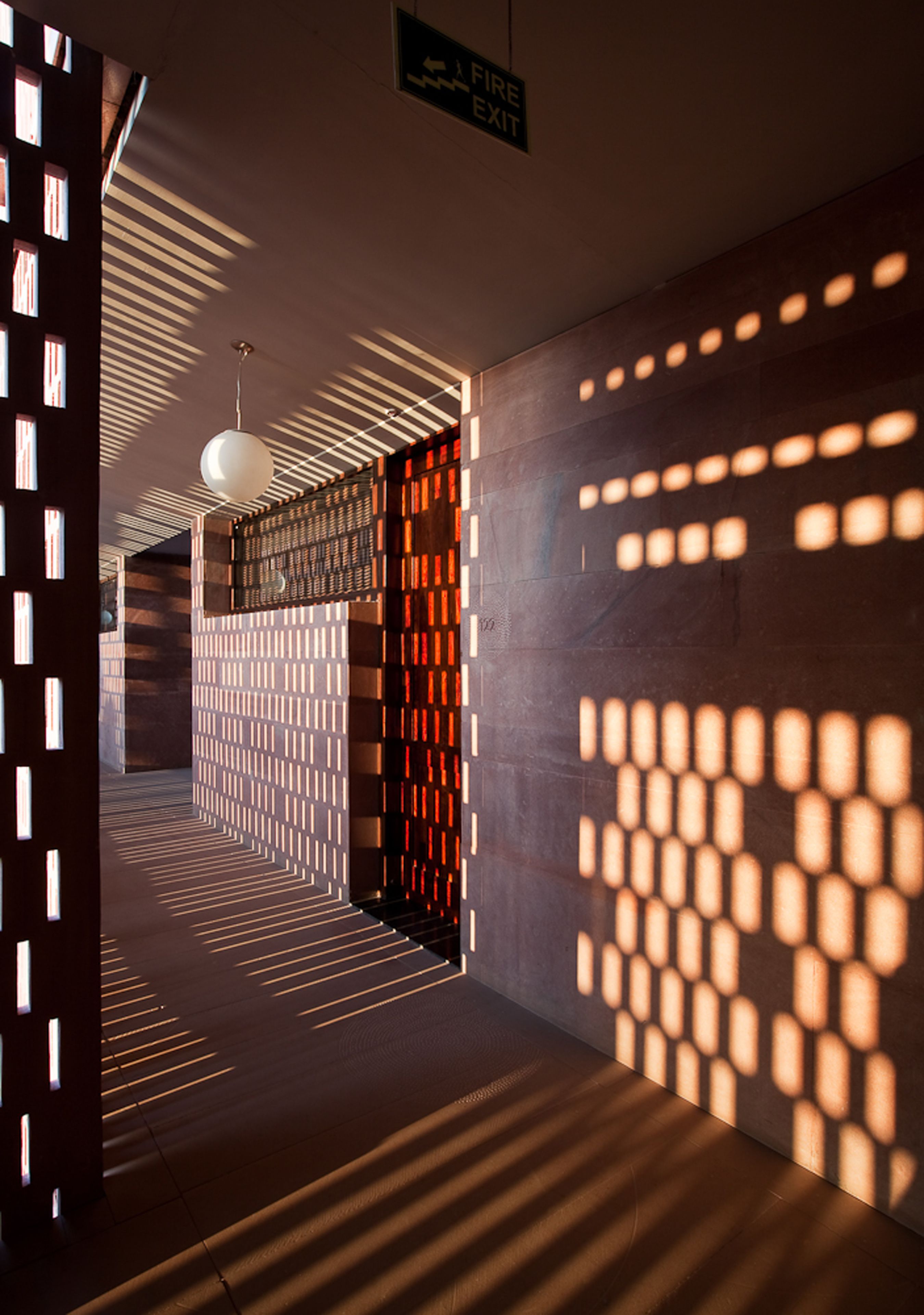 A corridor with patterned walls and a hanging light fixture.