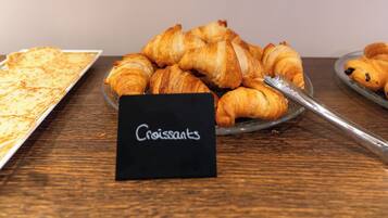 Ein Tisch mit Croissants und einem Schild mit der Aufschrift 'Croissants'.