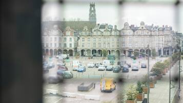 A view of a street with parked cars and a yellow van.