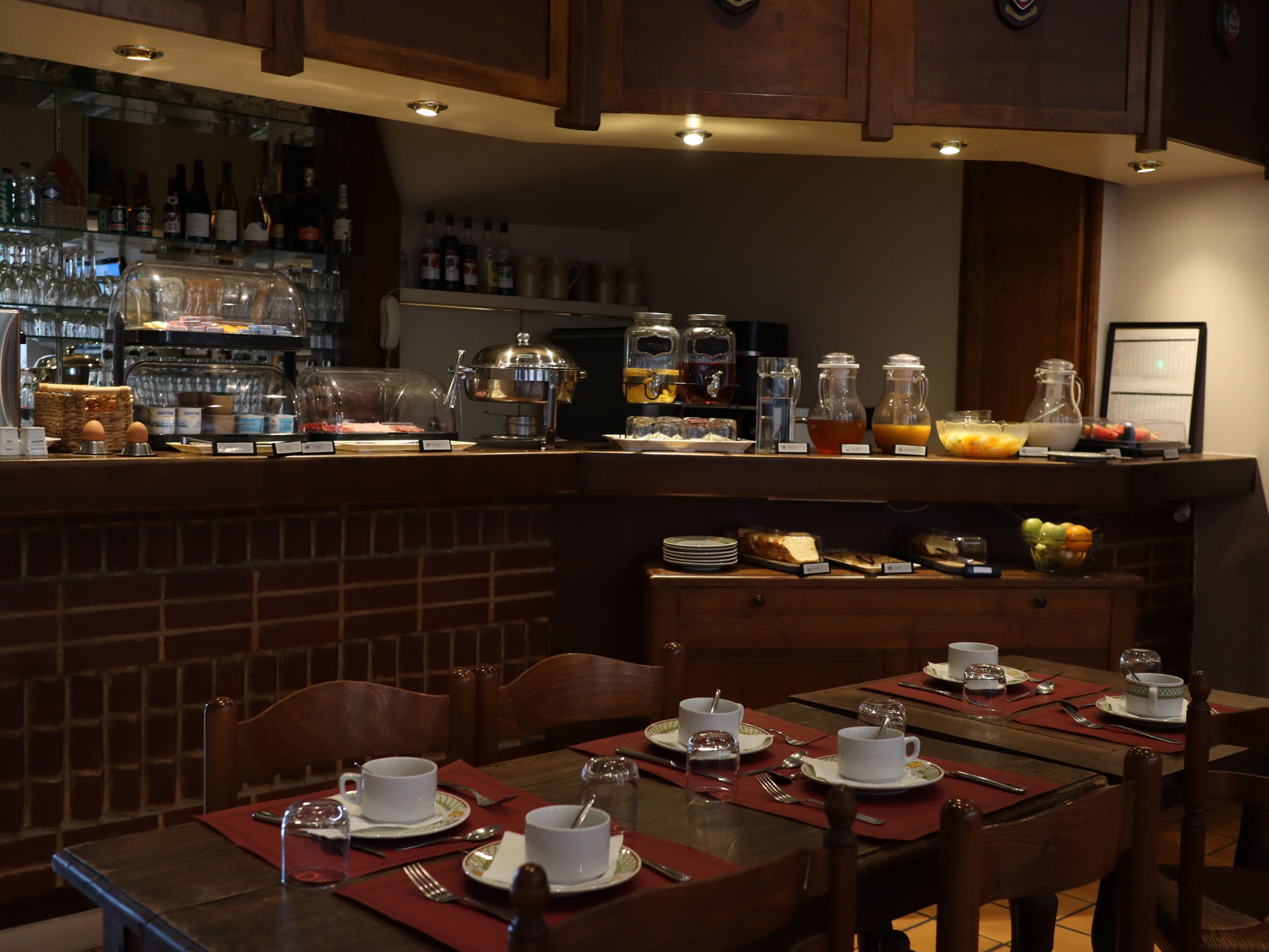 A breakfast bar with a variety of food and drink options, including a coffee machine, fruit, and a selection of beverages.