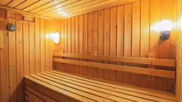 Una sauna de madera con bancos y luces en la pared.