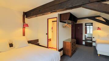 Een hotelkamer met een groot bed, een dressoir, een spiegel en een kapstok.